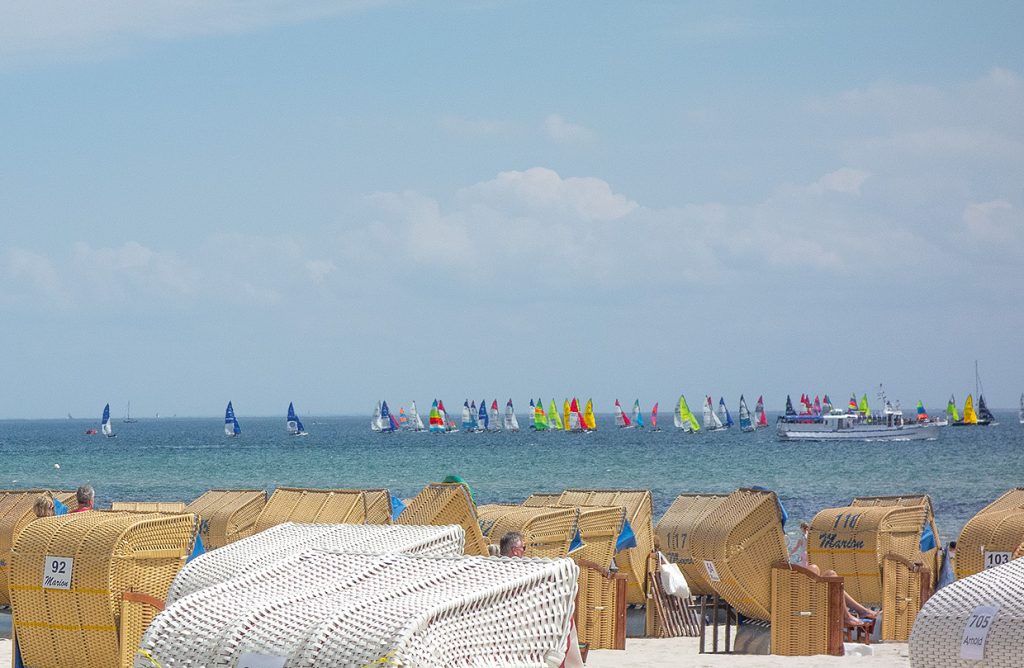 Der Strand von Grömitz: im Vordergrund Strandkörbe, dahinter die Ostsee mit vielen Segelbooten. Kontext: Job-Angebot Pädagoge, Pädagogin, Sozialpädagoge, Sozialpädagogin, Sozialarbeiter, Sozialarbeiterin in der Klinik am Meer